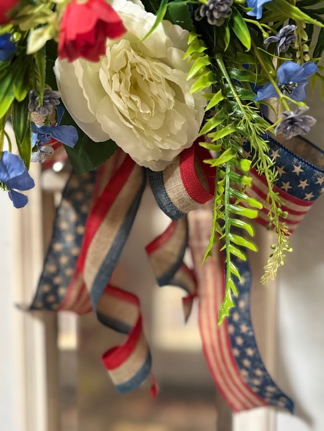 Detail of white peony with red, white and blue patriotic ribbons cascading down