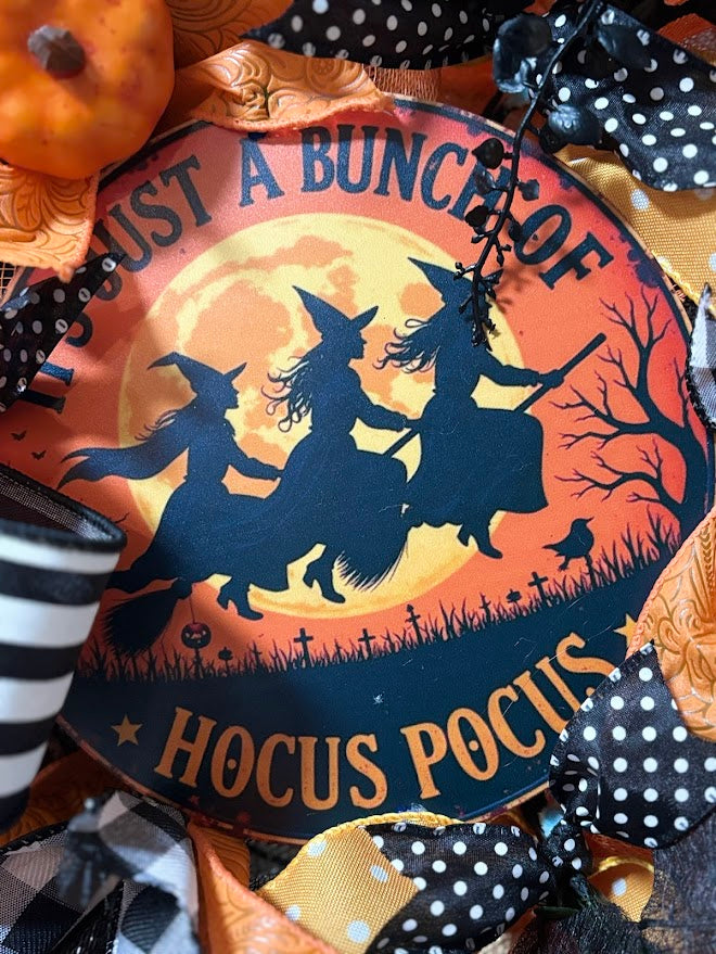 Close-up of Hocus Pocus sign with three witches flying on broomsticks under full moon