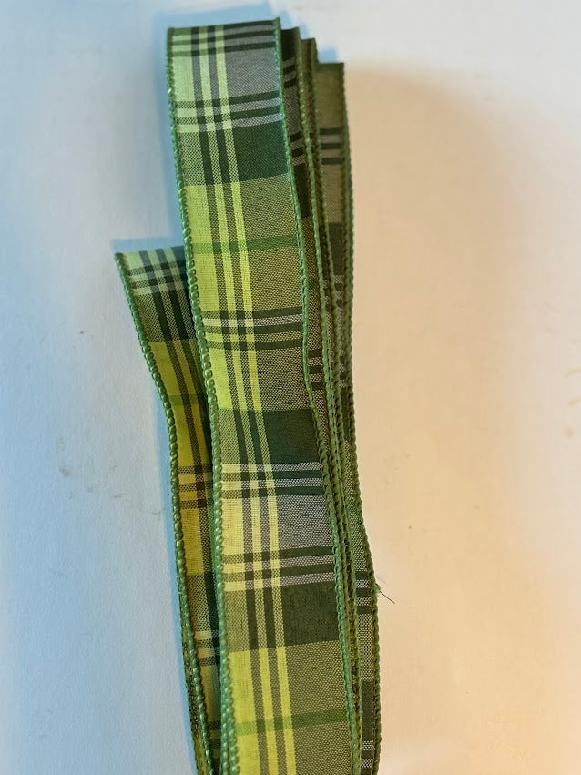 Sage green plaid wired ribbon in 1.5 inch width showing tartan pattern