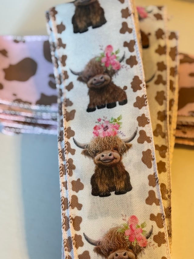 Close-up of highland cow with floral crown on wired ribbon