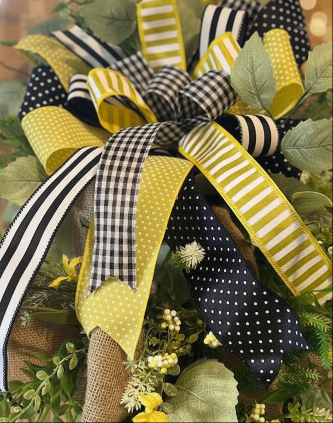 Close-up of Sunny Days Swag bow showing yellow polka dot, black gingham and stripe ribbons